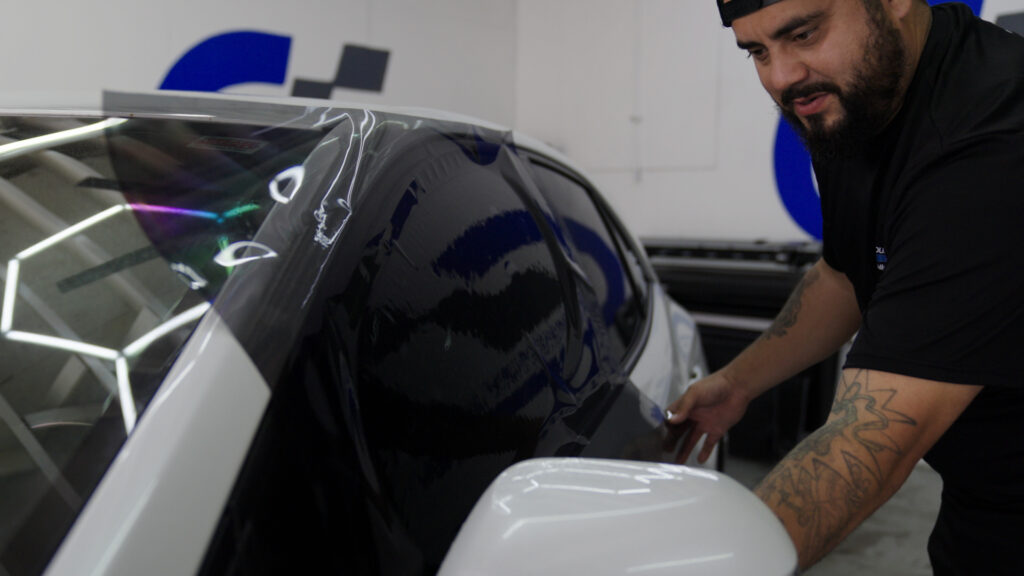 Professional installer applying automotive window tint to a vehicle in Corpus Christi, Texas