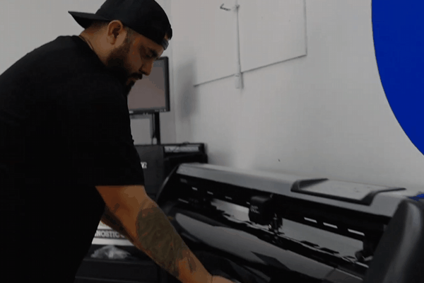 Professional technician preparing computer-cut automotive window tint film before installation in Corpus Christi, TX