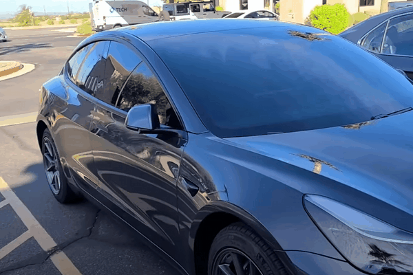 Gray vehicle with ceramic window tint showing dark tinted side windows and windshield